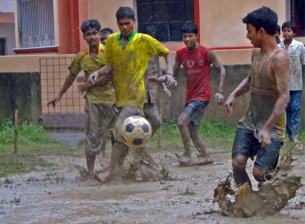Can you play soccer in the rain - Kids enjoying playing football in their neighbourhood in the rain