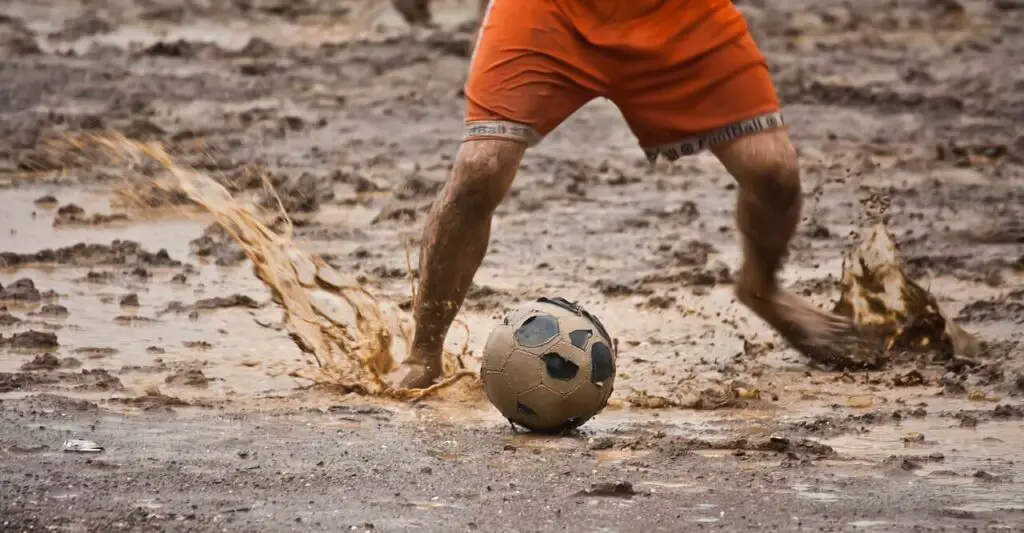 Can you play soccer in the rain - Kid playing soccer in bad pitch conditions and without shoes