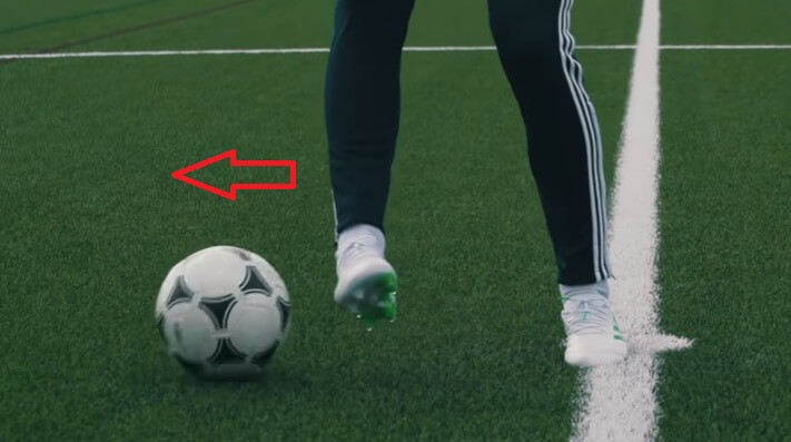 A soccer player controlling the ball in one touch and heading to one direction