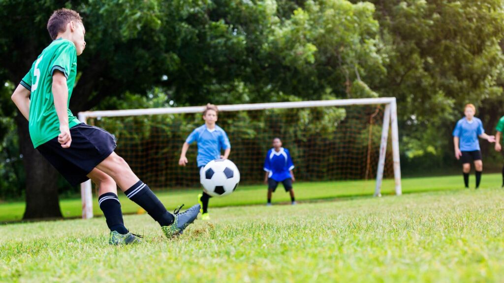 Best soccer positions for tall players - Image showing a player playing a long ball in the box to find a teammate