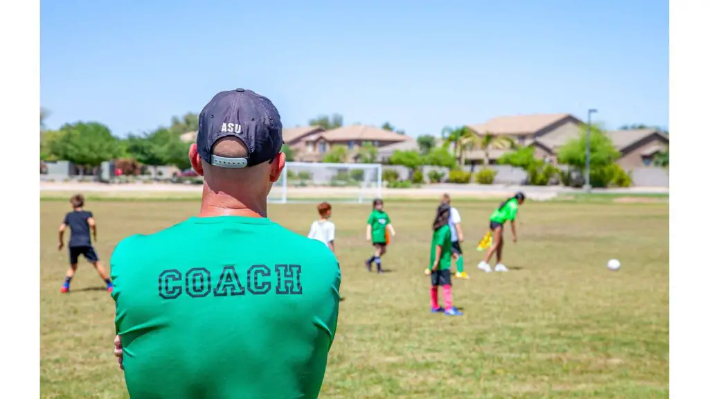 How to play soccer in college - Coach watching young soccer players