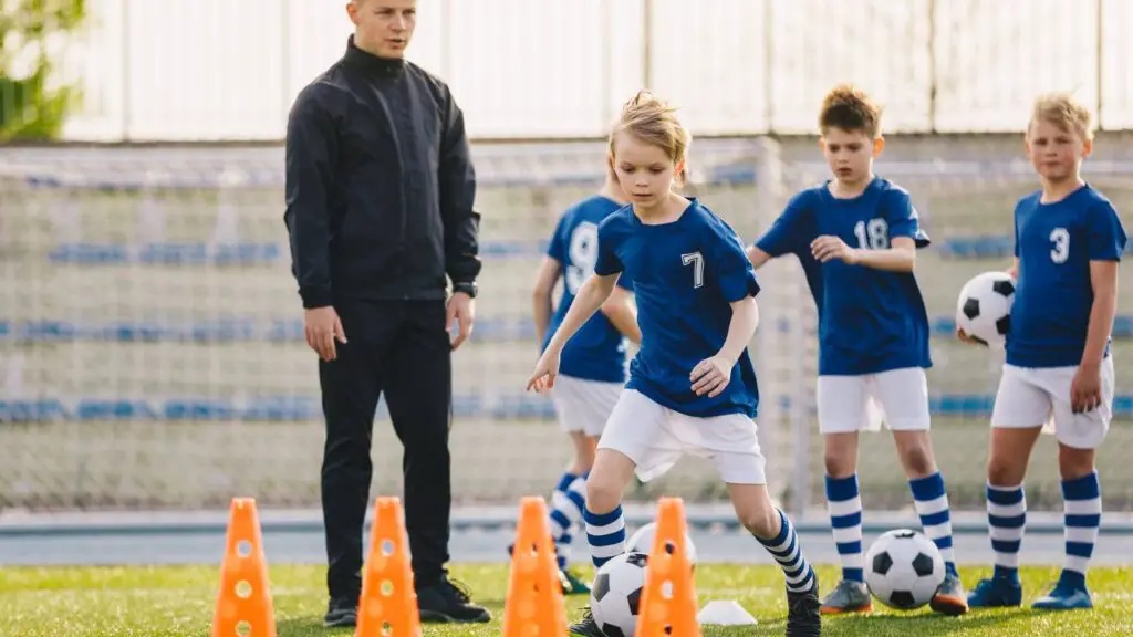 How to get scouted in soccer - Young soccer players practicing in front of their coach
