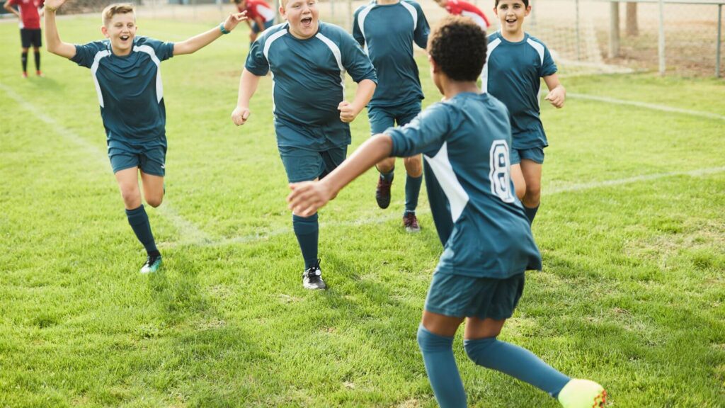 Motivation for soccer players - Young soccer players celebrating a win