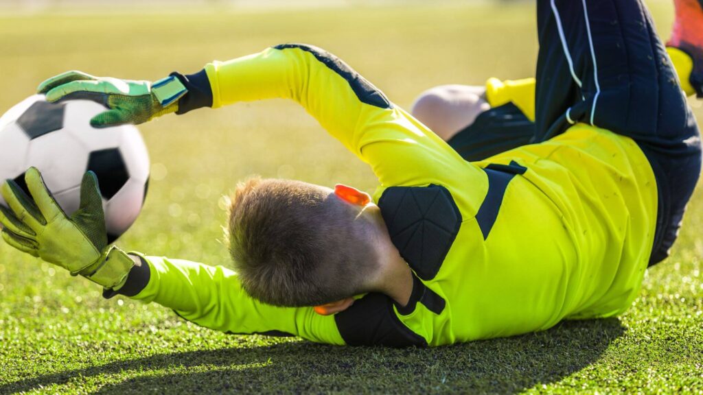 Why do Goalkeepers Spit on their Gloves - A soccer goalie catching the ball