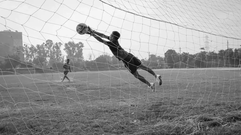 How long should goalie gloves last - black and white photo of a goalkeeper making a save