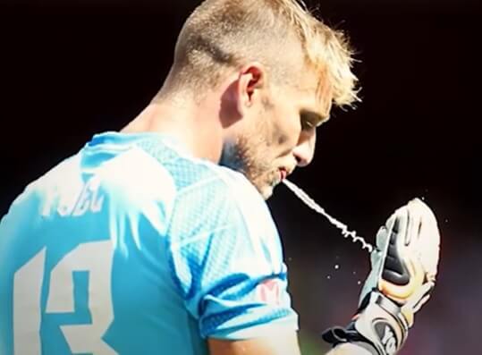 Why do Goalkeepers Spit on their Gloves - A soccer goalie spitting on his gloves