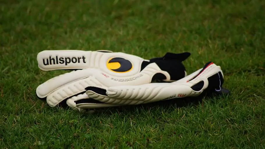 Goalkeeper glove brands - Uhlsport white gloves on the grass