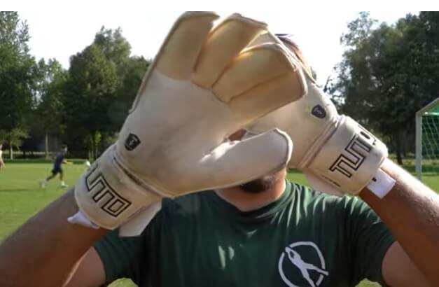 What Is The Difference Between Roll And Negative Cut - Someone showing a pair of roll cut glove