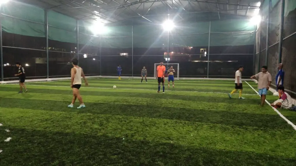 Difference between Futsal and Indoor soccer - Indoor soccer field with players by night