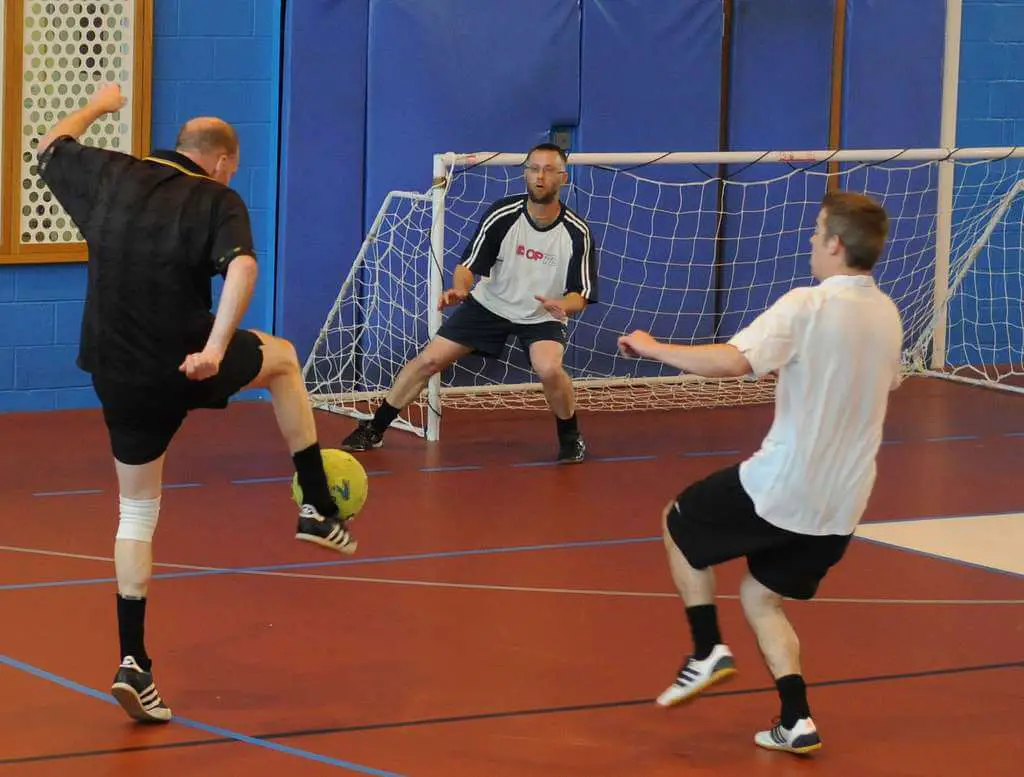 Indoor soccer goalie tips - Player hitting the ball with a volley and goalie on his feet