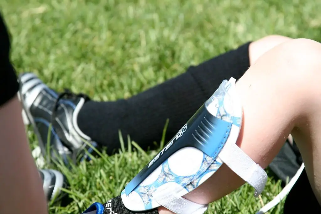 Soccer goalie protective gear - A player sitting on the pitch and wearing a shin guard