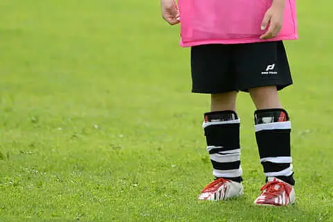 How do I know my shin guard size - A young soccer player wearing a too large pair of shin guard