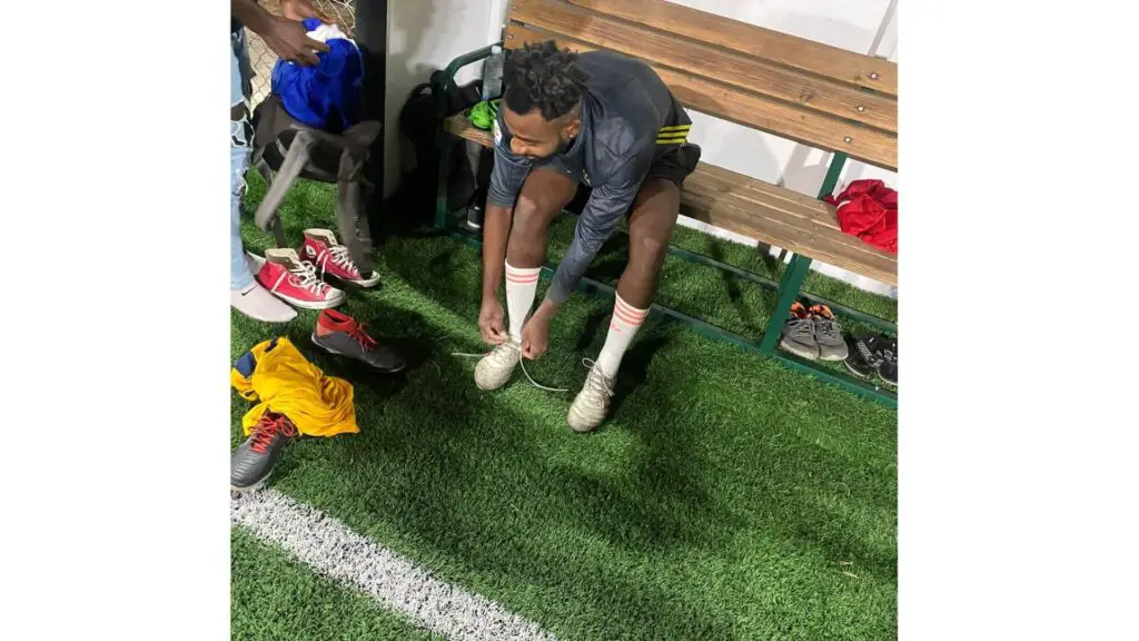 What's indoor soccer - Warren NZAMBI sitting and lacing up his cleats for a night game