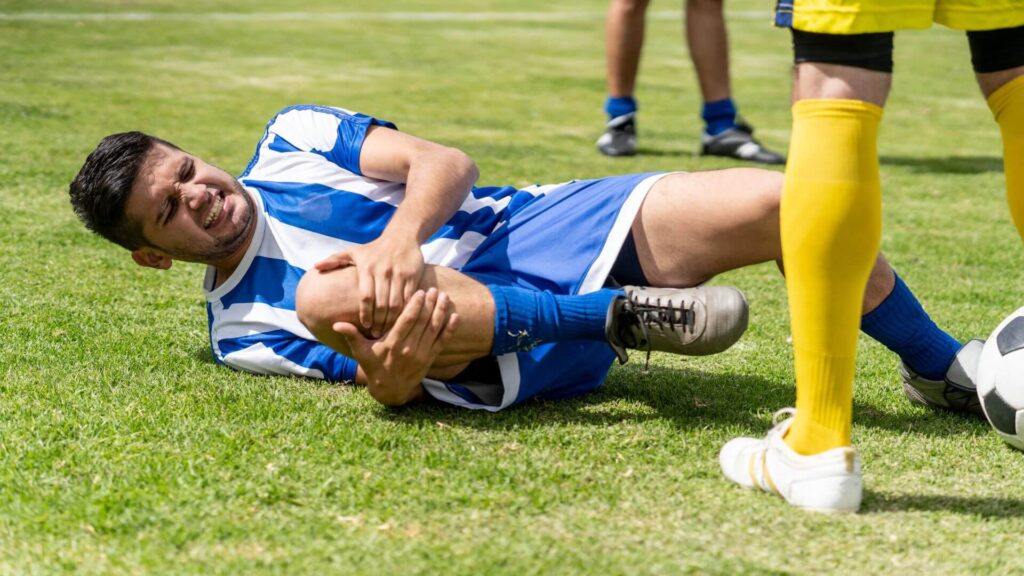 soccer yellow and red card rules - player on the ground in pain